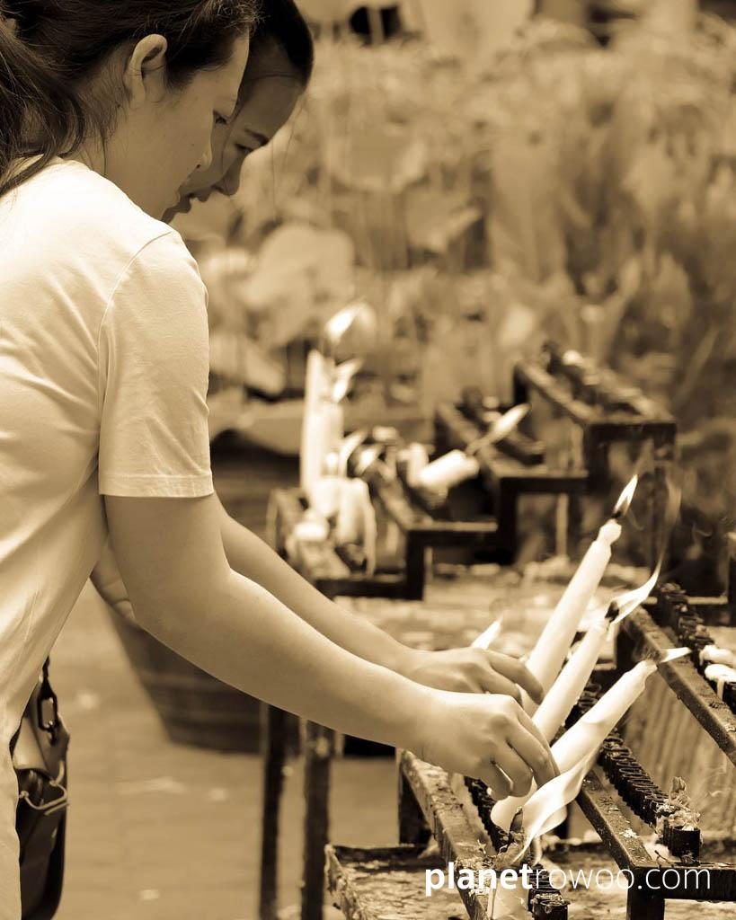 Buddhist girls making candle offerings at Wat Chai Mongkhon