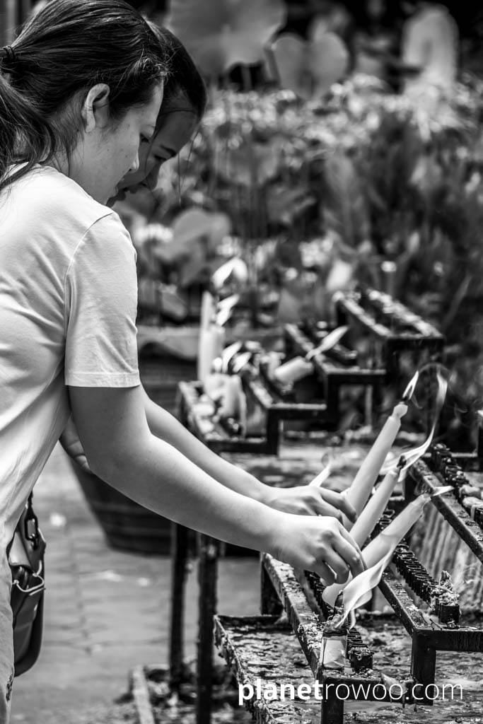Buddhist girls making candle offerings at Wat Chai Mongkhon