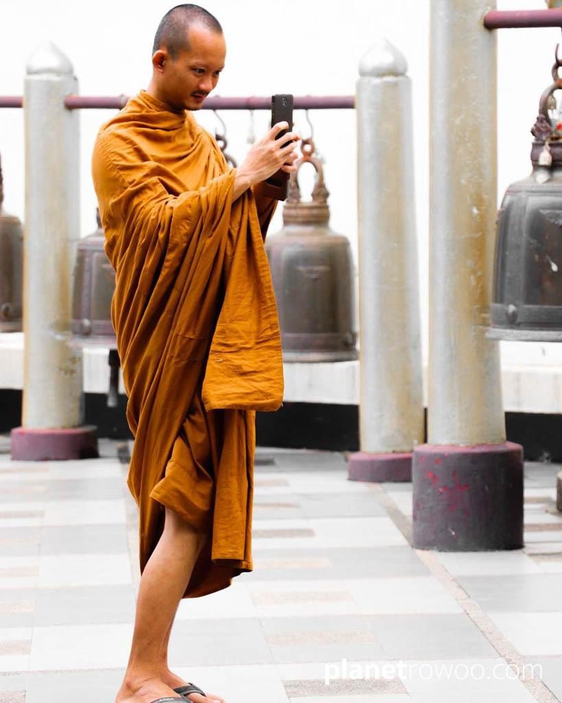 Buddhist monk takes a photo at Wat Phra That Doi Suthep