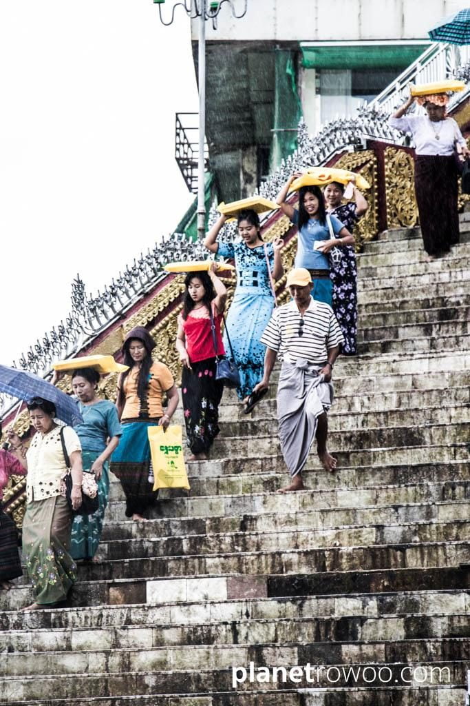 Pilgrims descend the Golden Rock steps in the rain