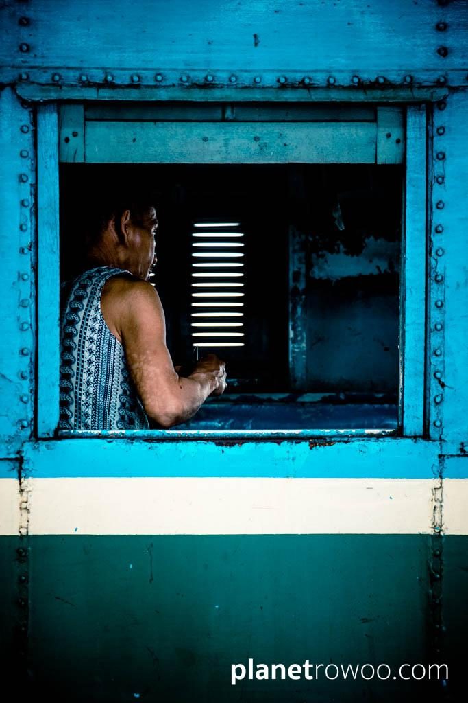 A traveller, through carriage window, Yangon Central station