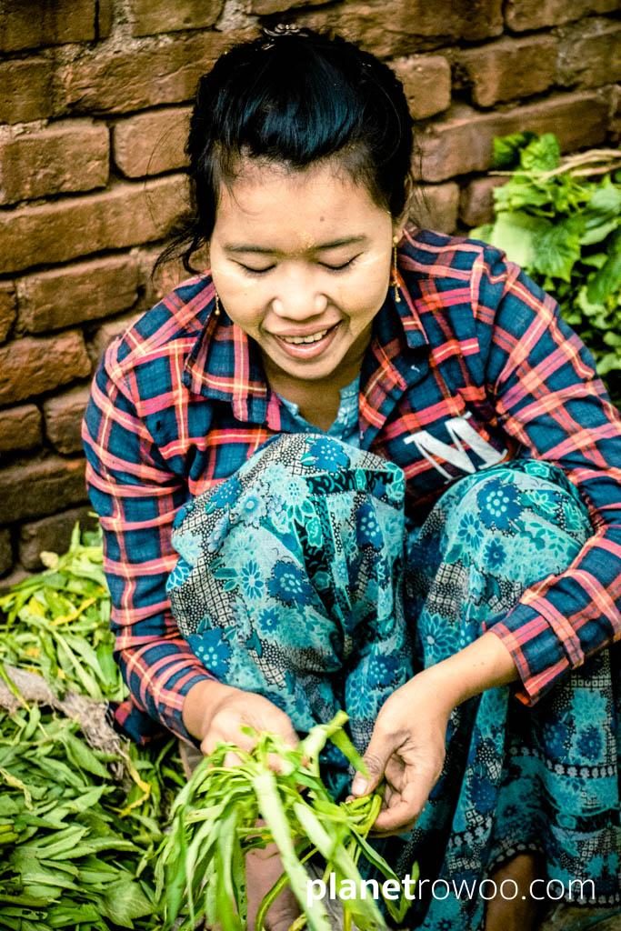 Smiley market vendor sorting her produce, Nyaung U market