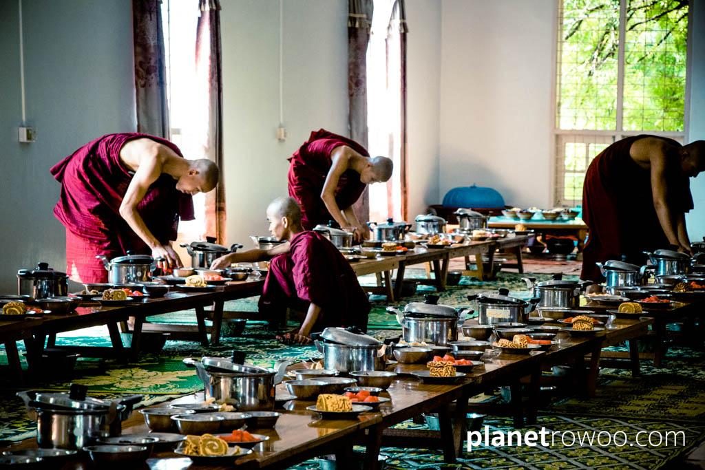 Novice monks prepare tables in Mandalay monastery dining hall