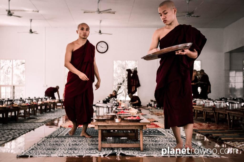 Novice monks prepare tables in Mandalay monastery dining hall
