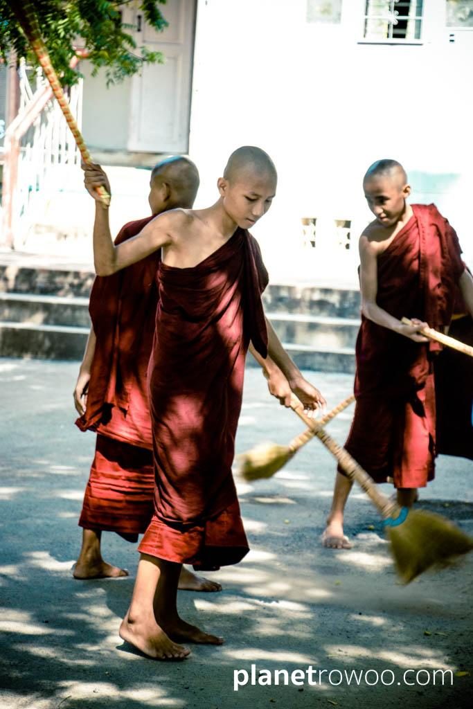 Novice monks sweeping monastery grounds