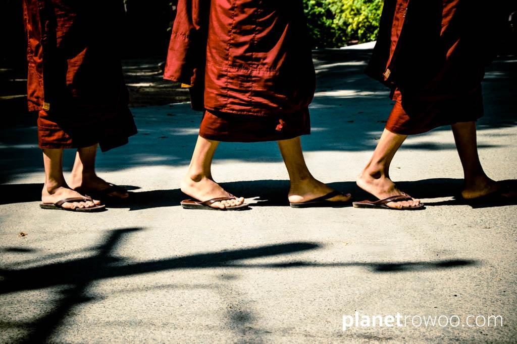 Monks maroon robes and flip-flopped feet at Mandalay monastery
