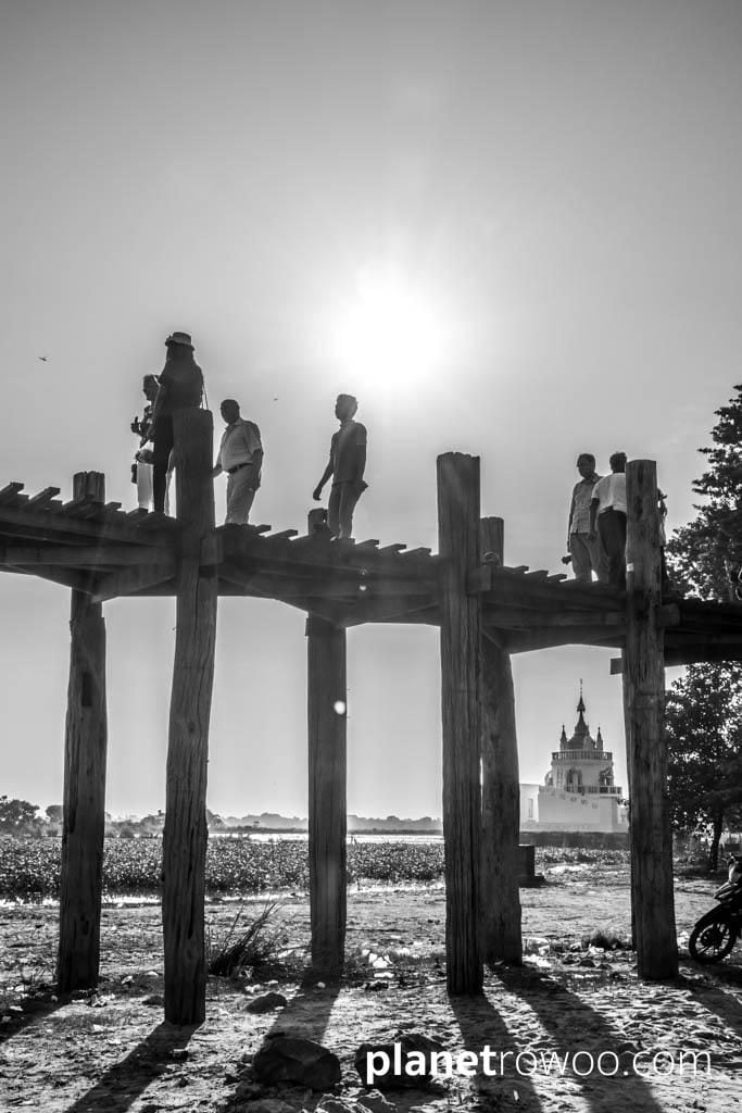 Sun goes down over the U Bein Bridge with temple in background