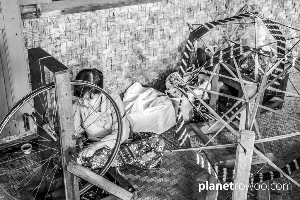 Spinning the silk thread on a spinning wheel with bicycle wheel, Inpawkhone weaving village