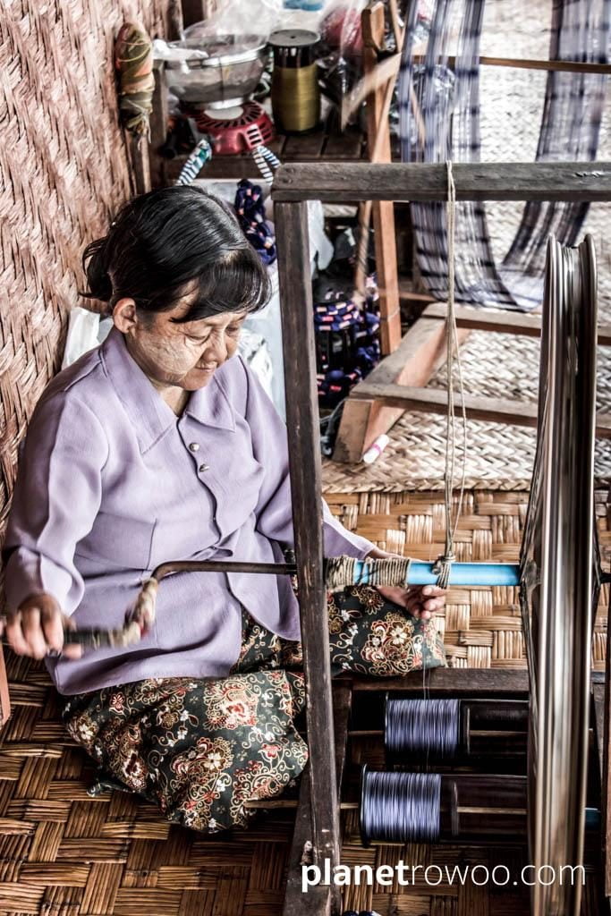 Spinning the silk thread on a spinning wheel with bicycle wheel, Inpawkhone weaving village