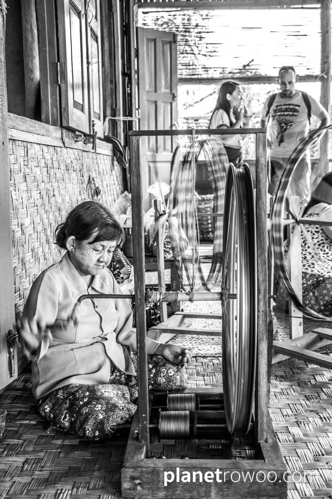 Spinning the silk thread on a spinning wheel with bicycle wheel, Inpawkhone weaving village