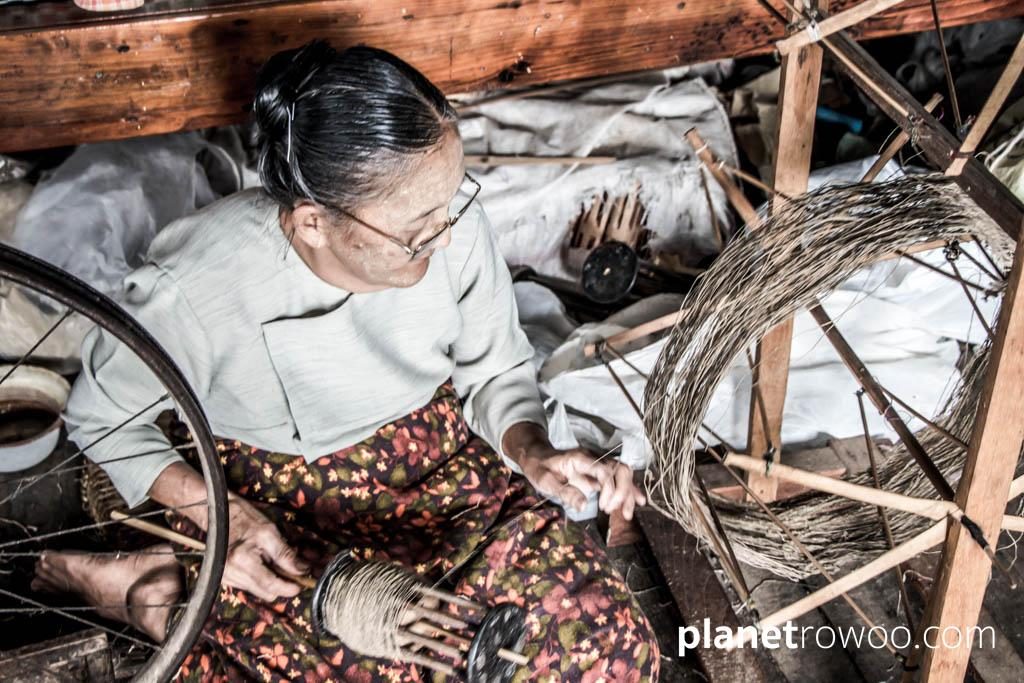 Spinning the silk thread on a spinning wheel with bicycle wheel, Inpawkhone weaving village