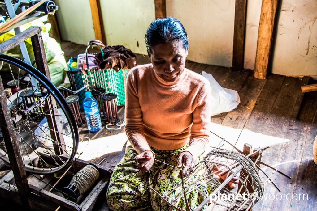 Spinning the silk thread on a spinning wheel with bicycle wheel, Inpawkhone weaving village