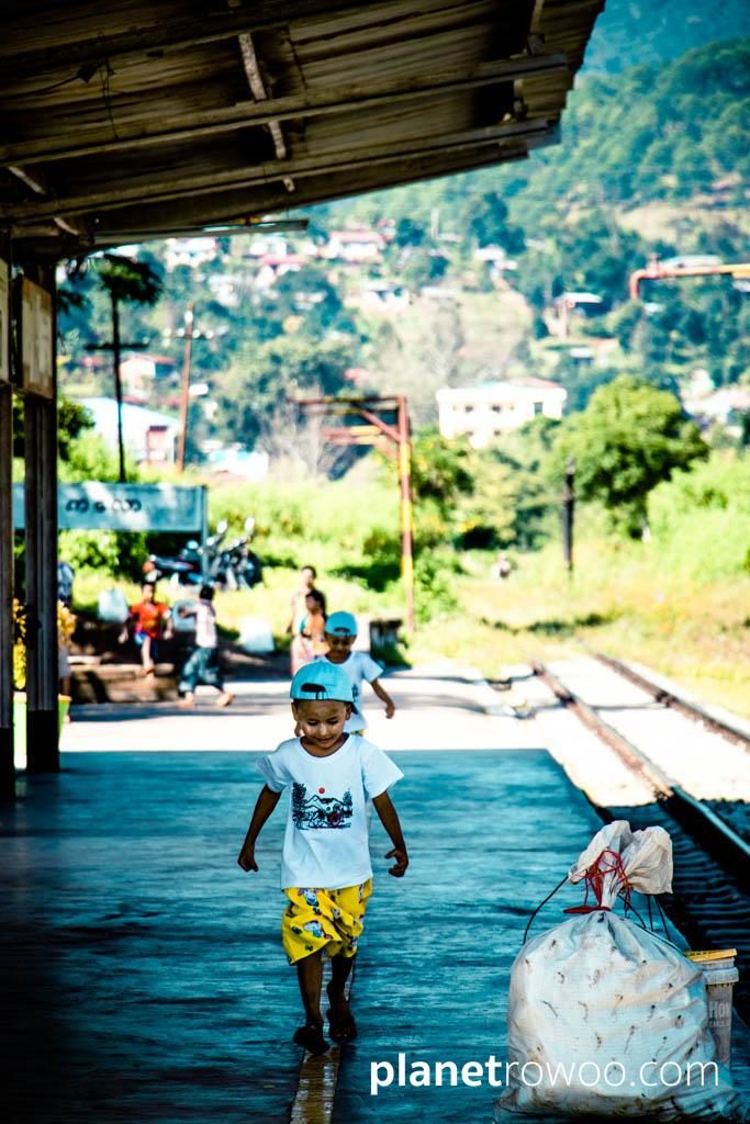 Kids walking the yellow line on Kalaw's train station platform
