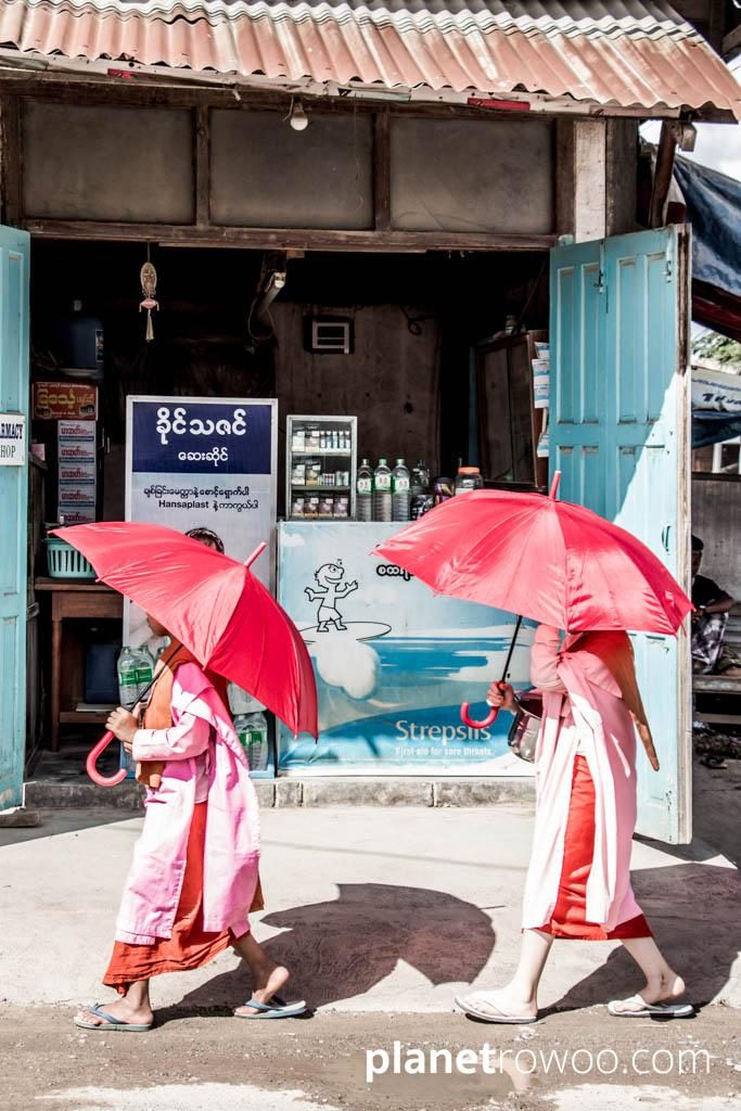 Nyaung Shwe nuns passing a storefront on Yone Gyi Street