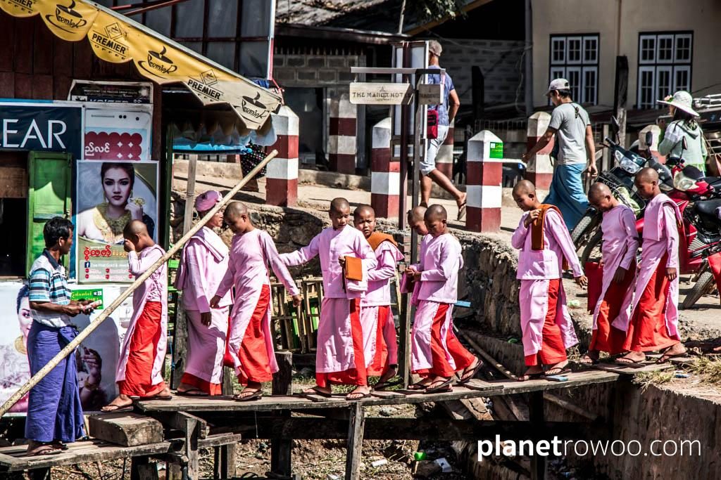 Nyaung Shwe nuns crossing a rickety walkway to the longtail boats