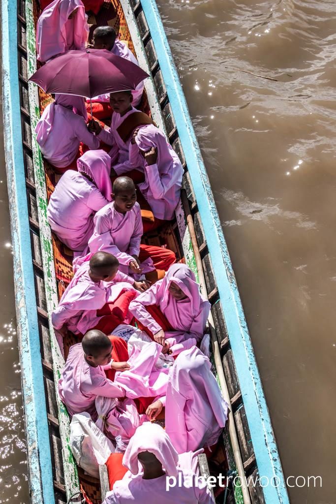 The striking pink of the Nyaung Shwe nun's robes is in stark contrast to the muddy water