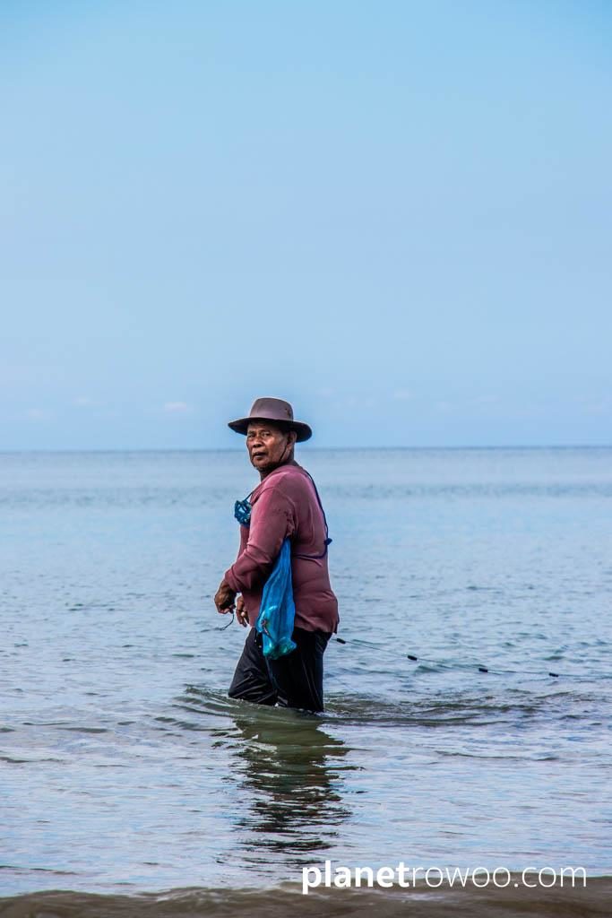 Fisherman in the shallow waters of Bangsak beach Khao Lak