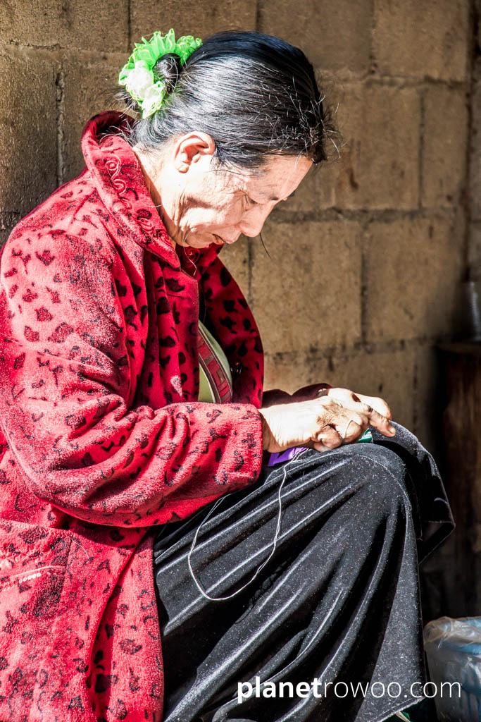 Lisu hill tribe villager sewing traditional wares