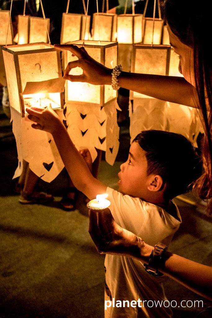 Lighting terracotta candle trays at Three Kings Monument, Yee Peng Festival Chiang Mai