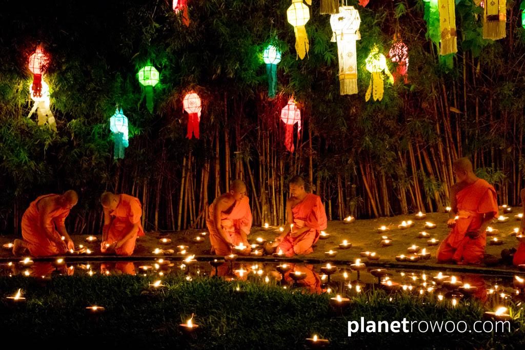 Novice monks float terracotta candle trays on the pond at Wat Phan Tao during the Yee Peng festival