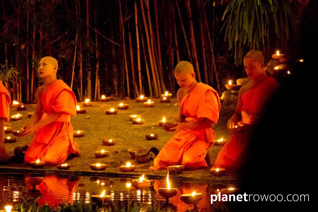 Novice monks float terracotta candle trays on the pond at Wat Phan Tao during the Yee Peng festival