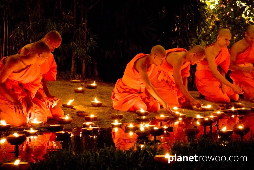 Novice monks float terracotta candle trays on the pond at Wat Phan Tao during the Yee Peng festival