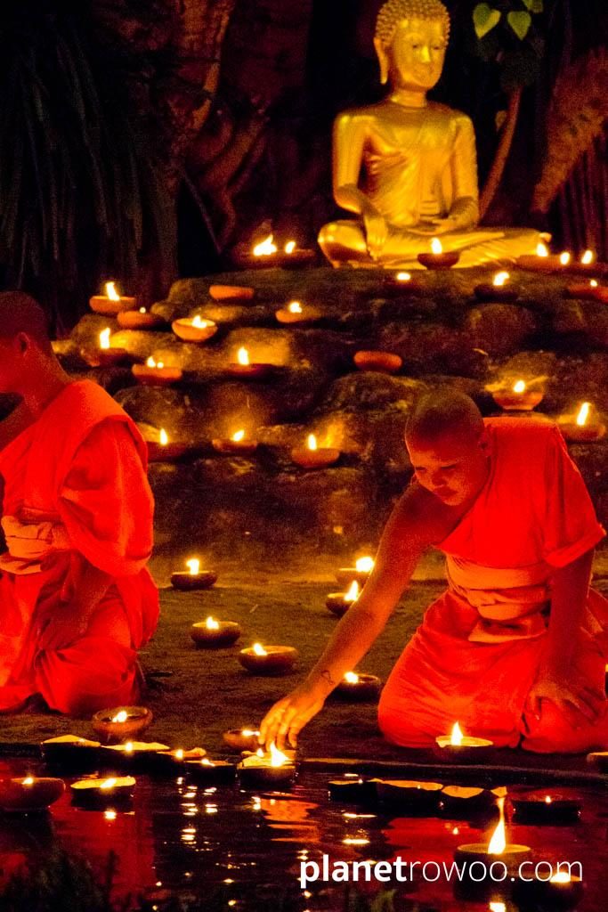 Novice monks float terracotta candle trays on the pond at Wat Phan Tao during the Yee Peng festival