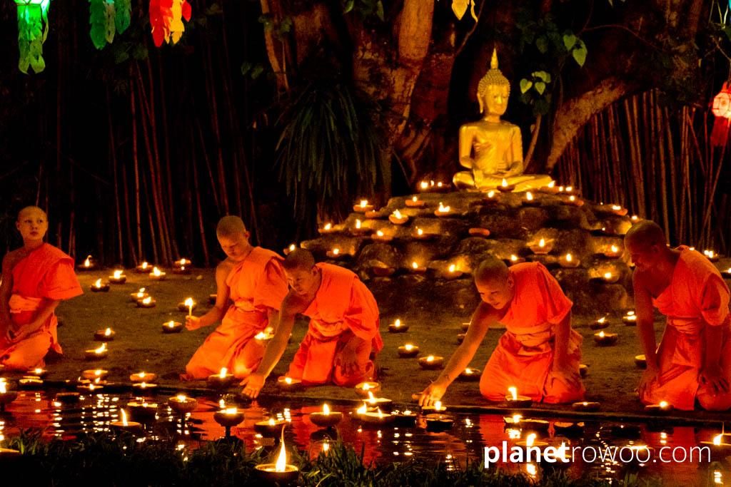 Novice monks float terracotta candle trays on the pond at Wat Phan Tao during the Yee Peng festival
