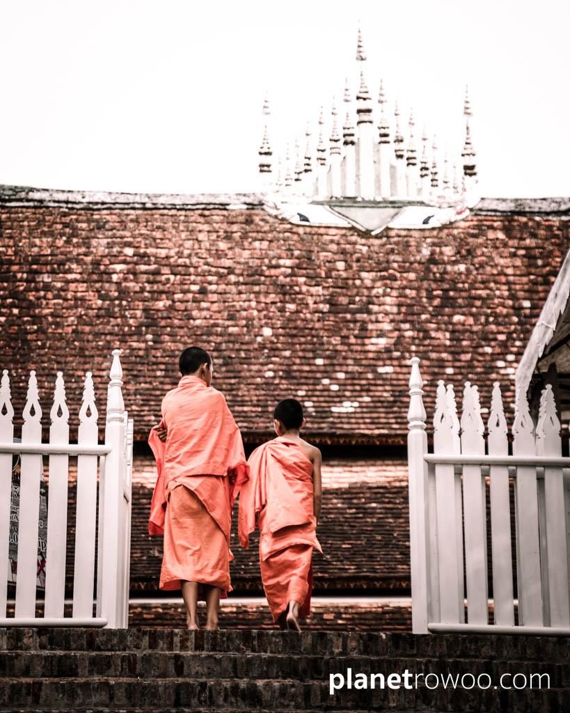 The entrance of Kings – Novice monks climb the broad stairway up to Wat Xieng Thong from the banks of the Mekong, Luang Prabang, Laos